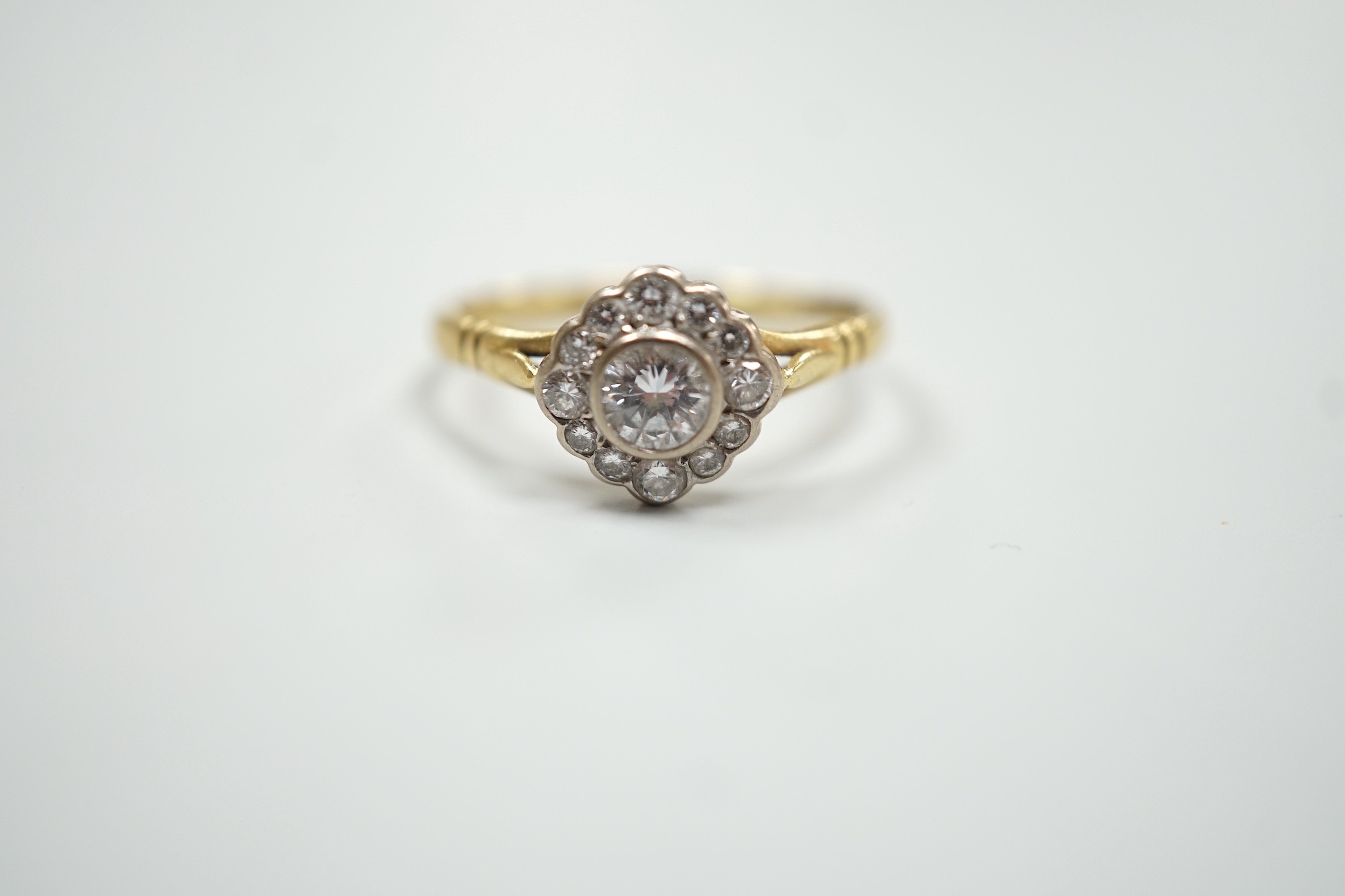 A modern 18ct gold and single stone diamond ring, with diamond set border, size S, gross weight 3.2 grams.
